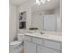 Modern bathroom featuring white cabinets, large mirror, neutral walls and tile at 2526 Winsome Way, Davenport, FL 33896