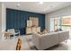 Bright living room with a modern sofa, blue accent wall, and sliding glass doors leading to the patio at 2526 Winsome Way, Davenport, FL 33896