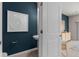 Stylish powder room with a blue accent wall, decorative art, and modern fixtures at 2526 Winsome Way, Davenport, FL 33896