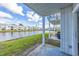 Covered patio with lush green grass leads to a tranquil lake view at the rear of the property at 2540 Woodgate Blvd # 106, Orlando, FL 32822