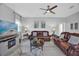 Bright living room featuring a ceiling fan, leather furniture, and a decorative fireplace at 281 Edisto Pl, Apopka, FL 32712