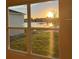 Window view overlooking a tranquil lake with sunset enhancing the peaceful ambiance of the home at 2921 Sunridge Loop, St Cloud, FL 34771