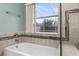 Bathroom features a tiled shower and tub with a window overlooking the pool at 2980 Viscount Cir, Kissimmee, FL 34747