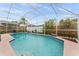 Enclosed pool with sunny exposure surrounded by tropical plants and greenery at 2980 Viscount Cir, Kissimmee, FL 34747