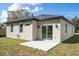 Exterior view of home's rear featuring sliding glass door and a small concrete patio at 313 Mandrake St, Orlando, FL 32811