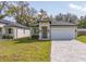 Charming one-story home featuring a two car garage, a well-maintained lawn, and a paved driveway at 313 Mandrake St, Orlando, FL 32811