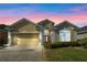 Charming single-story home features a manicured lawn, brick driveway, and an attached two-car garage at 322 High Vista, Davenport, FL 33837