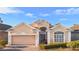 Inviting one-story residence showcasing a lush lawn, brick driveway, and an attached two-car garage at 322 High Vista, Davenport, FL 33837