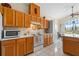 Charming kitchen featuring wood cabinets, white appliances, and a cozy breakfast nook at 322 High Vista, Davenport, FL 33837