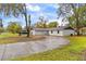 Beautiful home exterior featuring a long, curved driveway and lush landscaping at 3325 Dove Ln, Mulberry, FL 33860