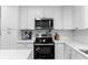 Close-up of a modern kitchen featuring white cabinets and countertops, plus stainless steel appliances at 3325 Dove Ln, Mulberry, FL 33860