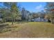 Backyard view featuring large trees, green lawns, and a home at 3508 Rouse Rd, Orlando, FL 32817