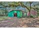 A sturdy green shed with a roll-up door, perfect for storage or workshop space at 3508 Rouse Rd, Orlando, FL 32817