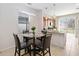 Cozy dining area next to the kitchen with a glass-top table and modern light fixture at 3566 Southern Cross Loop, Kissimmee, FL 34744