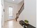 Bright foyer with tile flooring, staircase with wooden banister, and a decorative glass front door at 3566 Southern Cross Loop, Kissimmee, FL 34744