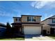 Two-story tan home with a two-car garage, well-manicured lawn, and beautiful landscaping at 3566 Southern Cross Loop, Kissimmee, FL 34744