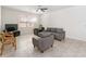 Comfortable living room featuring tile floors, a ceiling fan, and ample seating arrangements at 3566 Southern Cross Loop, Kissimmee, FL 34744