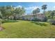 Apartment building featuring a lush green lawn and mature trees under a clear blue sky at 4214 Lake Underhill Rd # A, Orlando, FL 32803