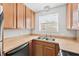 Kitchen area with wood cabinets, laminate countertops, a stainless steel sink, and a window above the sink at 4312 Lake Underhill Rd # 19, Orlando, FL 32803