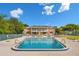 Community pool with lounge chairs and a two-story brick building in the background against a bright blue sky at 4312 Lake Underhill Rd # 19, Orlando, FL 32803