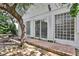 Patio area with brick pavers near a home, with a lush tree providing natural shade at 44 Capistrano Dr, Ormond Beach, FL 32176