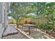 Backyard shaded by lush trees, a table, and a brick walkway along the home's exterior at 44 Capistrano Dr, Ormond Beach, FL 32176