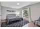 This bedroom features tile floors, a comfortable bed, a chair, and a bright window at 44 Capistrano Dr, Ormond Beach, FL 32176