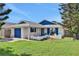 Charming single-story home with blue accents, a front porch seating area, and a well-manicured lawn at 44 Capistrano Dr, Ormond Beach, FL 32176