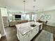 Modern kitchen island with granite countertops offering a clear view of the living room and staircase at 453 Oviedo Blvd, Oviedo, FL 32765