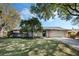 Charming single-story home with a well-manicured lawn, mature trees, and stone accents at 460 Forestwood Ln, Maitland, FL 32751