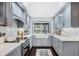 Updated kitchen featuring grey cabinetry, farmhouse sink, white countertops, and stainless steel appliances at 460 Forestwood Ln, Maitland, FL 32751