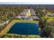 Aerial view of the property with a pond in the background surrounded by trees at 5142 Sage Cedar Pl, Sanford, FL 32771