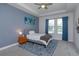 Cozy bedroom with blue accent wall, tray ceiling, and large windows offering natural light at 5142 Sage Cedar Pl, Sanford, FL 32771