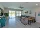 Bright living room with tile floors, large sectional sofa, and sliding glass doors to the lanai at 5142 Sage Cedar Pl, Sanford, FL 32771