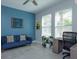 Office features blue accent wall, ceiling fan, two windows, desk, and comfortable seating at 5142 Sage Cedar Pl, Sanford, FL 32771