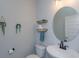 A simple powder room has a round mirror, floating shelves and gray walls at 5142 Sage Cedar Pl, Sanford, FL 32771