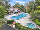 Community pool and spa surrounded by lounge chairs and greenery at 520 Via Verona Lane # 103, Altamonte Springs, FL 32714