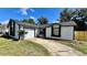 Exterior shot of a one story home with white siding, grey roof and an attached garage at 5317 Hyde Park Ave, Orlando, FL 32808