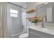 Bright bathroom featuring white subway tile, floating shelves, and a gray vanity with storage at 611 Aldama Ct, Ocoee, FL 34761