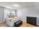 Well-lit bedroom featuring wood floors, a large window, and a chest for ample storage space at 611 Aldama Ct, Ocoee, FL 34761