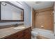 Bathroom featuring a granite countertop and a shower with tan tiling and a white bathtub and toilet at 6336 Buford St # 706, Orlando, FL 32835