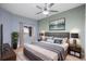 Comfortable bedroom with a ceiling fan, modern lamps, and beautiful artwork hanging above the bed at 6336 Buford St # 706, Orlando, FL 32835