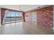 Spacious living room featuring brick accent wall, wood floors, and water view at 6336 Buford St # 706, Orlando, FL 32835