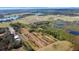 Expansive aerial view of a property with fields, lakes, and lush greenery under a bright blue sky at 8122 Pine Island Rd, Clermont, FL 34711