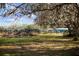 Large backyard with some shade from the trees and an old, fenced in structure at 8122 Pine Island Rd, Clermont, FL 34711