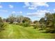 Beautiful driveway lined with palm trees, and a lush green lawn under a blue sky at 8122 Pine Island Rd, Clermont, FL 34711