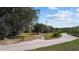 Gravel driveway winding through lush greenery and mature trees, showcasing the property's natural beauty at 8122 Pine Island Rd, Clermont, FL 34711