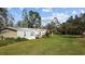 Exterior shot of a single story home, featuring a lush green lawn and mature trees at 8122 Pine Island Rd, Clermont, FL 34711