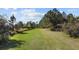 Exterior view of the property with a lush green lawn under a sunny sky with scattered clouds at 8122 Pine Island Rd, Clermont, FL 34711