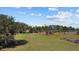 Exterior view of the property with agriculture plots under a sunny sky with scattered clouds at 8122 Pine Island Rd, Clermont, FL 34711